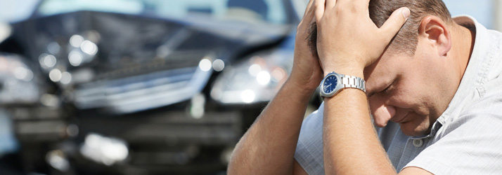 Distressed man holding his head after a car crash, highlighting need for chiropractic treatment in Medway for car accident injuries.