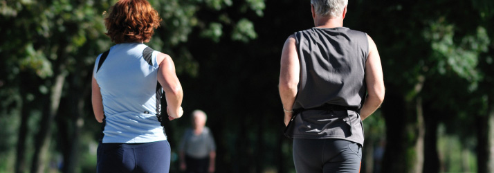 Man and woman jogging together through a sunny park, highlighting how to exercise smarter for better health in Medway.