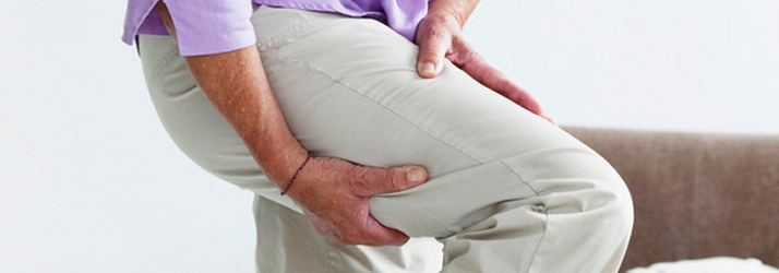 Person holding their upper thigh in pain, illustrating chiropractic care and targeted relief for sciatic leg pain in Medway MA.