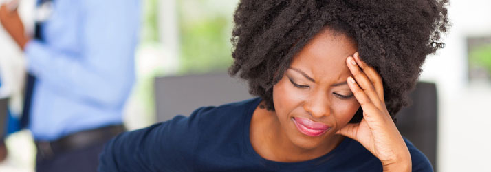 Woman clutching her head in pain, illustrating how natural chiropractic care from Medway chiropractors may help relieve severe migraines.